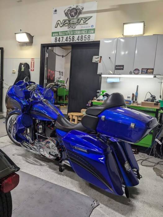 detailed home motorcycle repair, intense expression, fixing electrical wiring, photorealistic, compact garage with wire bundles and open panels, highly detailed, precise wire connections, 35mm lens, neutral colors, focused task lighting
