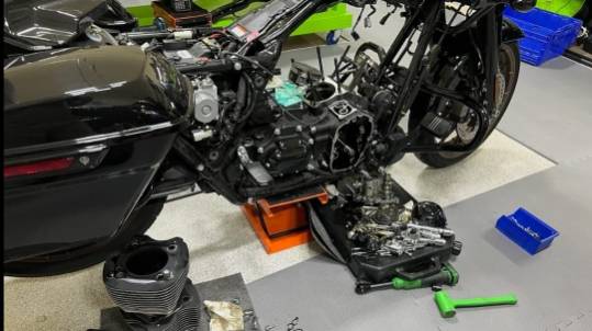 precise maintenance repair, skillfully executed, tightening bolts, photorealistic, automotive garage setting, highly detailed, sparks from welding, 35mm lens, warm, tungsten lighting, shot with a Panasonic GH5.