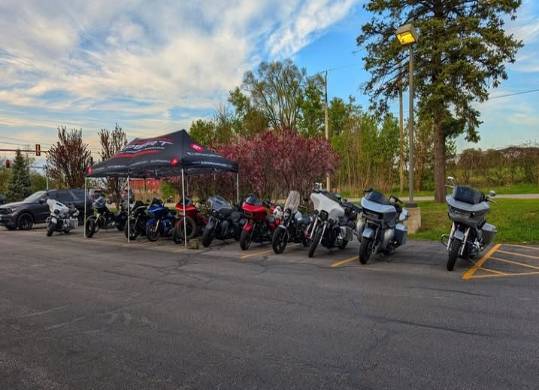 vintage bike fest, joyful celebration, biking alongside carnival rides, photorealistic, lively festival atmosphere with string lights, highly detailed, motion blur of spinning rides, aperture f/4, warm pastel colors, lantern glow, shot with a 24mm lens.